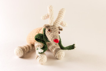Cute knitted deer toy with green scarf