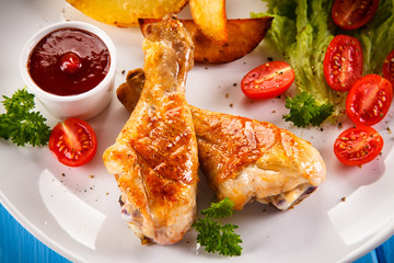 Grilled chicken legs with chips and vegetables 