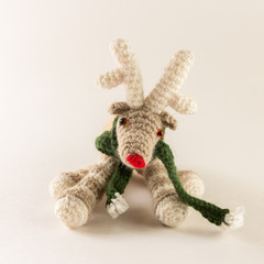 Cute knitted deer toy with green scarf