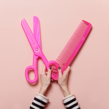 Hand Holding Pink Scissors And Comb