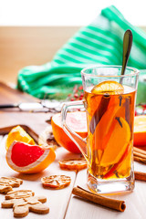 Winter hot drink with spices on wooden table.