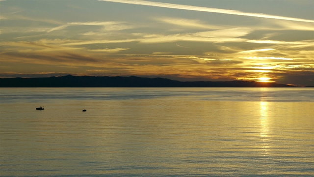 Small boats on calm sea in sunset on Adriatic coast in Croatia