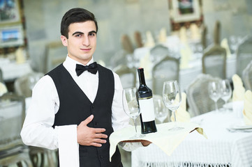 Waiter holding bottle of wine and glasses