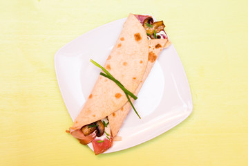 Flatbread with bacon and mushrooms on green table top view