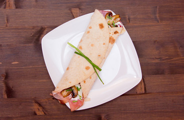 Flatbread with bacon and mushrooms on wooden table top view