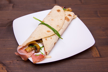 Flatbread with bacon and mushrooms on wooden table