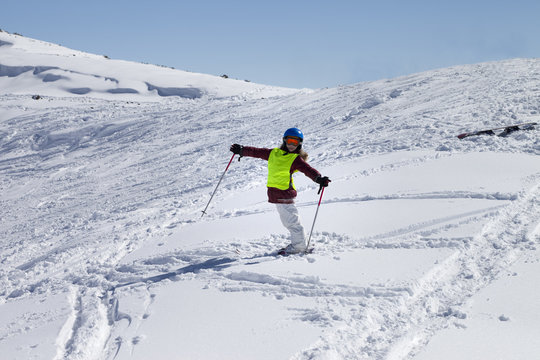 Little skier on ski slope with new fallen snow at sun day
