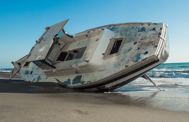 A boat run aground on a deserted beach.