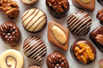 Assorted aligned bonbons on a white textured paper Top view