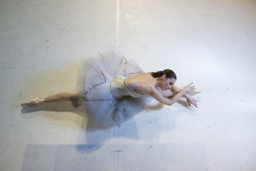 Young ballerina lying on floor, elevated view on her back © HD92