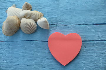 Blank paper note with heart shape on grunge blue wooden background with copy space