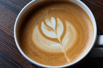 Cup of Latte Art Coffee on Wooden Table