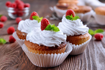Delicious cupcakes with berries and fresh mint on wooden table close up