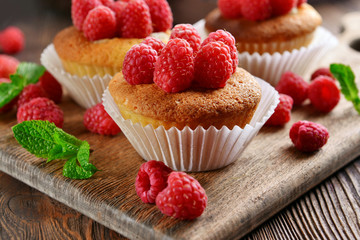 Delicious cupcakes with berries and fresh mint on wooden table close up
