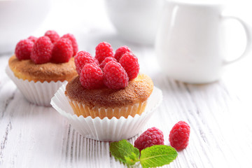 Delicious cupcakes with berries and fresh mint on wooden table close up
