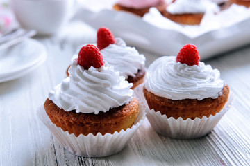 Delicious cupcakes with berries on table close up