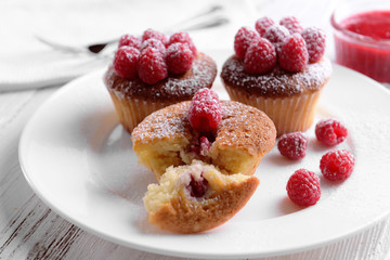 Delicious cupcakes with berries on plate close up