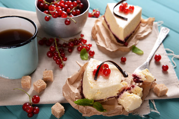 Tasty cheesecake with berries and cup of tea on table close up