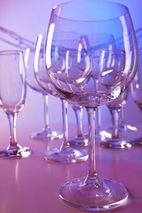 Empty wine glasses on color background