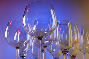 Empty wine glasses on color background