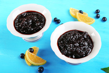 Tasty currant jam with berries on table close up