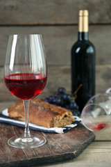 Still life of wine and bread on rustic wooden background