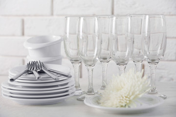 Clean dishes on table on brick wall background
