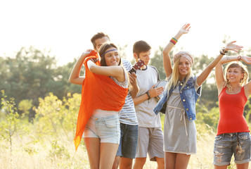 Obraz premium Joyful smiling friends dancing in the forest outdoors