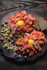Close-up of salmon tartare with egg yolk on a chopping board