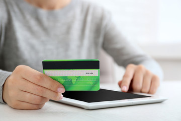 Concept for Internet shopping: hands with digital tablet and credit card