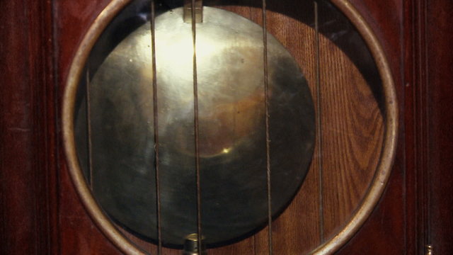 The swinging pendulum clock.Chimes.Time.