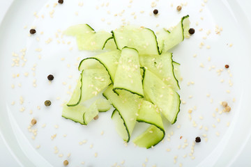 Sliced cucumbers dish on white plate in the restaurant, close up