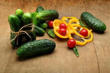 Composition of cucumbers, tomatoes and sweet peppers circles on wooden background