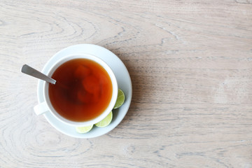 Cup of ginger lemon tea on the wooden table