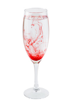 Full wineglass with red stains isolated on a white background