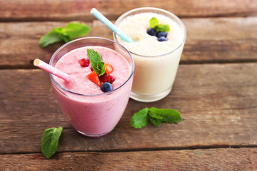 Fresh strawberry and milk yogurts with berries on wooden background