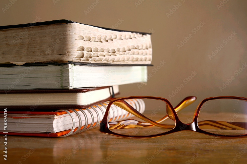 Wall mural Eyeglasses and pile of books - Wall murals