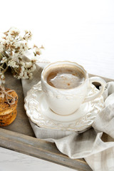 Cup of coffee and pile of tasty cookies with chocolate crumbs on wooden tray