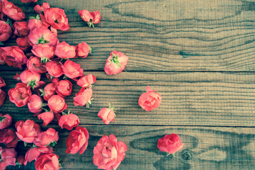 red roses on wooden background, vintage denim effect