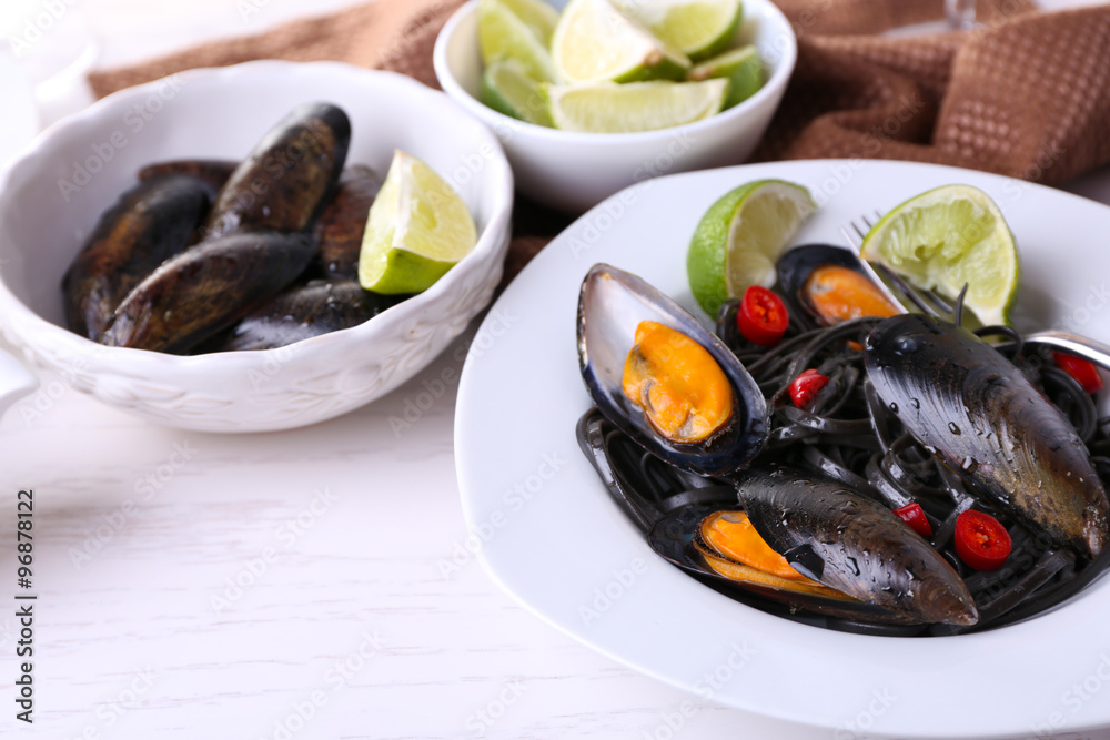 Sticker cooked pasta, mussel and lime on the table, close-up