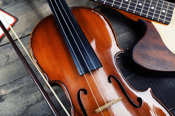 Electric guitar and violin on wooden background