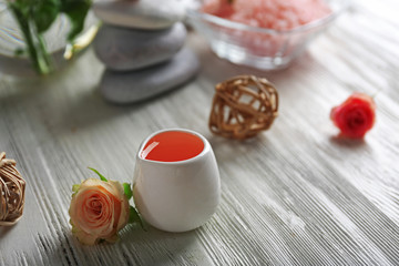 Composition of flowers, salt and stones on white wooden background, in spa salon