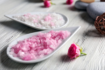 Composition of flowers, salt and stones on white wooden background, in spa salon