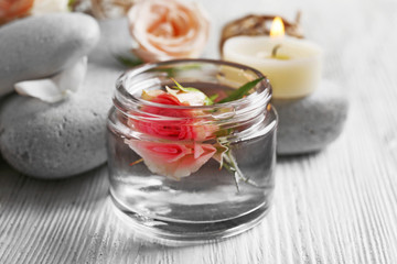 Composition of flowers, candles and stones on white wooden background, in spa salon