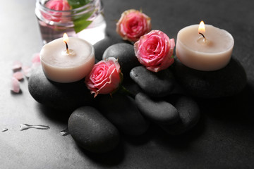 Spa composition of candles,  stones and flowers, on grey background