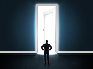 Fototapeta premium Business man looking at big bright opened door