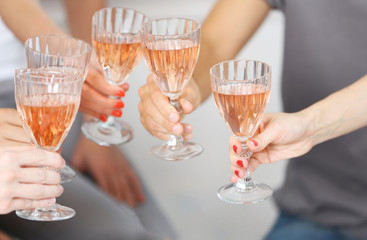 Friends hands with glasses of pink wine, close up