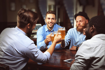 Young men drinking beer and talking in cafe