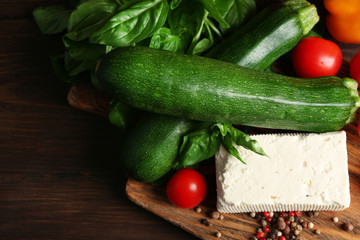 Fresh ingredients for preparing zucchini rolls on wooden background