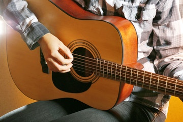 Guitarist plays guitar in the room, close up